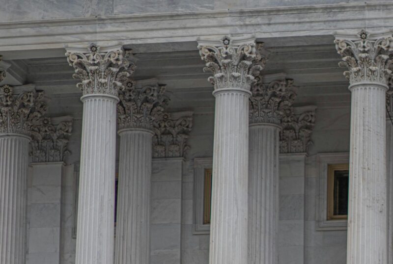 Neoclassical architecture of Capitol Building in Washington, DC, with security presence.