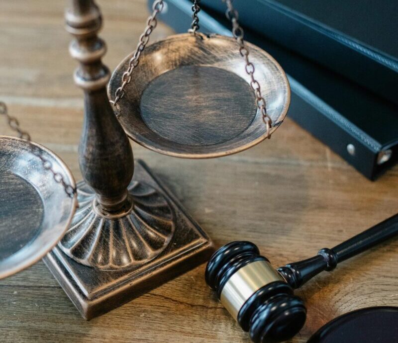 From above of judicial symbols consisting of Scales of Justice and small judge hammer with curly handle